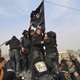 Iraqi-government forces celebrate while holding an Islamic Sate flag northeast of Baghdad on Jan. 26, 2015, near the town of Muqdadiyah.
YOUNIS AL-BAYATI/AFP/Getty Images)